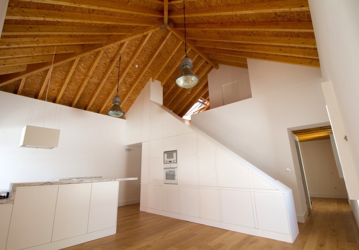 Sala da Casa da Baixa depois da intervenção, com pé-direito duplo e mezanino em madeira